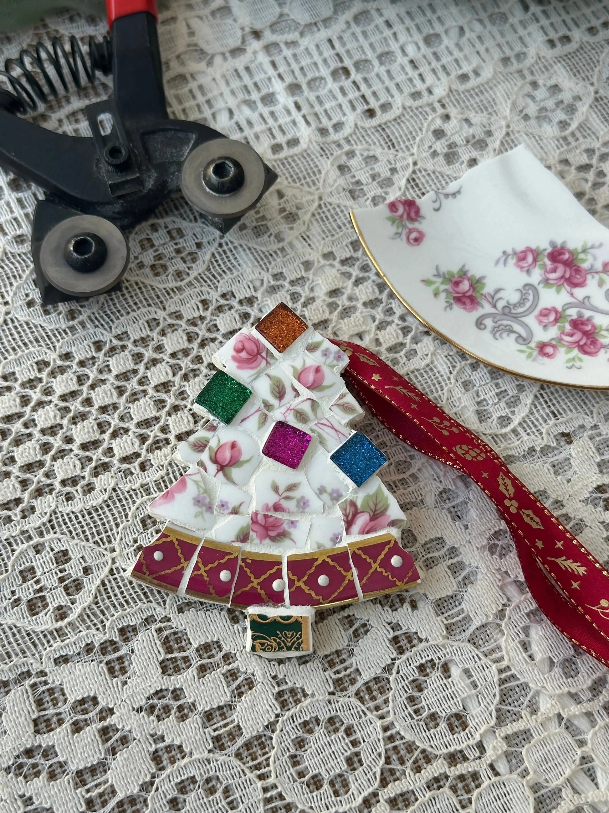 Upcycled ceramic mosaic Christmas tree ornament made from broken vintage floral china with crafting tools